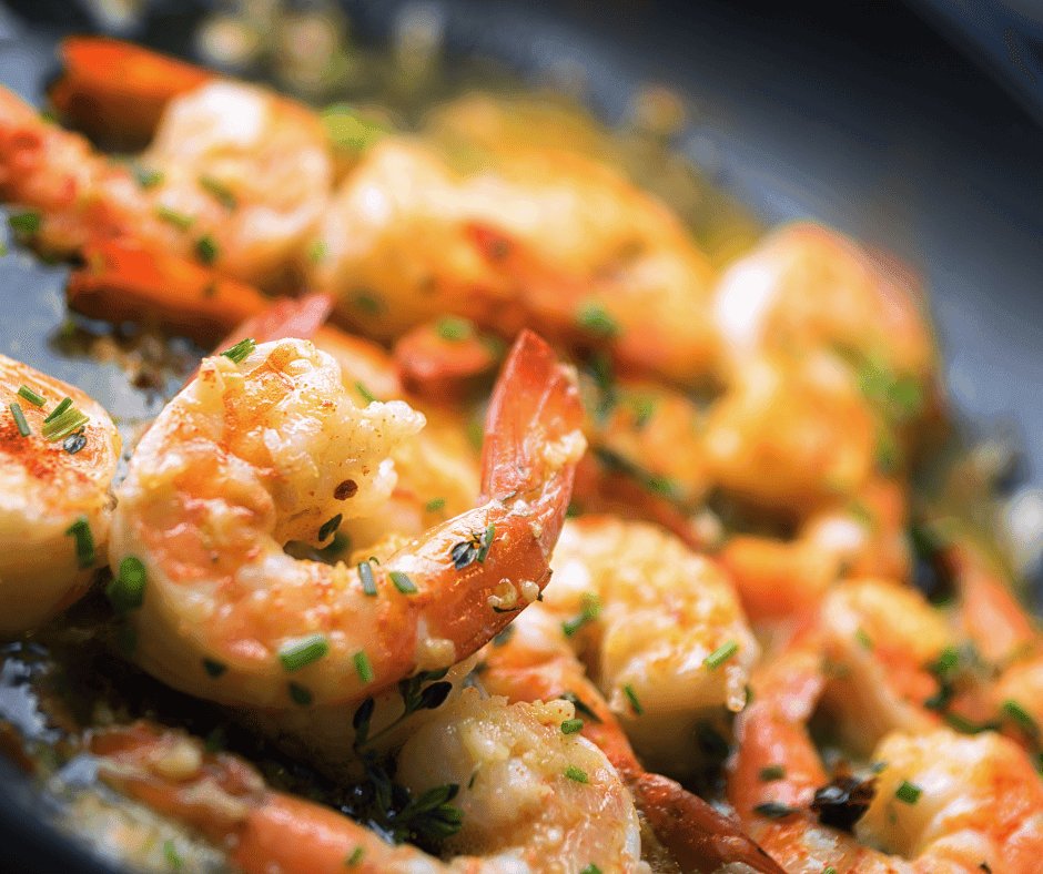A plated shrimp scampi dish garnished with parsley and lemon