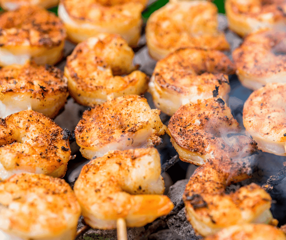 Amazing BBQ Shrimp: A Louisiana Classic 1 A flat-lay display of BBQ shrimp, butter sticks, lemon slices, garlic cloves, and a bowl of Cajun seasoning on a rustic wooden table