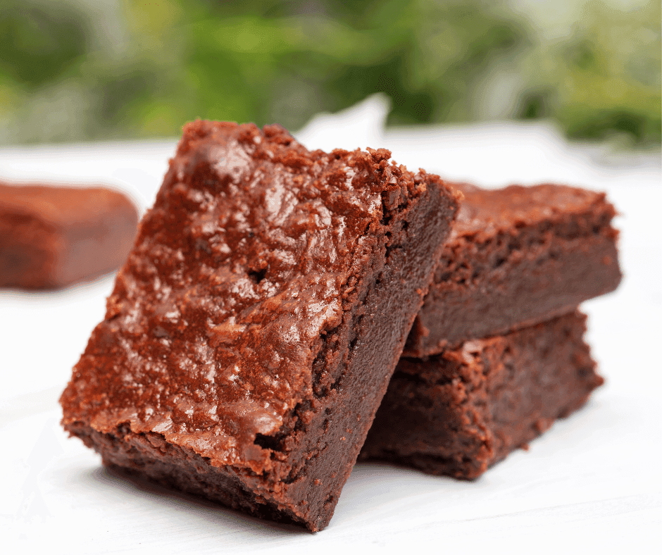 A finished brownie cake cooling on a wire rack, topped with shiny ganache