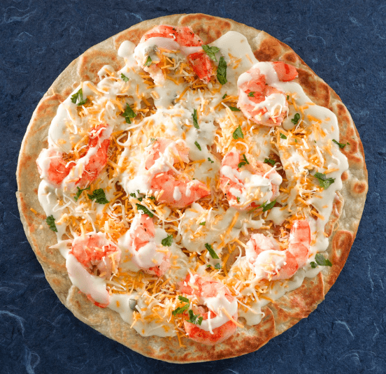Seafood Pizza topped with shrimp, shredded cheese, and a drizzle of creamy white sauce. The vibrant shrimp and scattered fresh herbs add pops of color against the lightly toasted crust, creating a visually appetizing dish